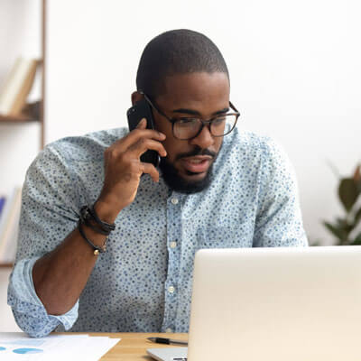 Man At Computer On Phone